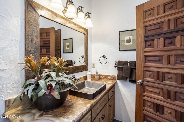 bathroom with a textured wall and vanity