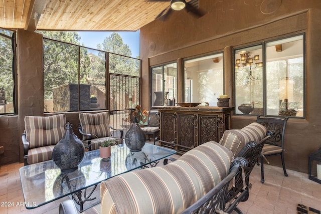 sunroom featuring vaulted ceiling, wood ceiling, a healthy amount of sunlight, and ceiling fan