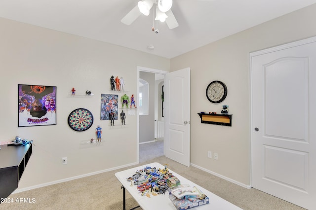 interior space featuring ceiling fan and light colored carpet