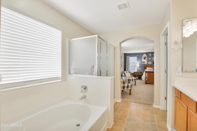 bathroom with tile patterned flooring, plus walk in shower, and vanity