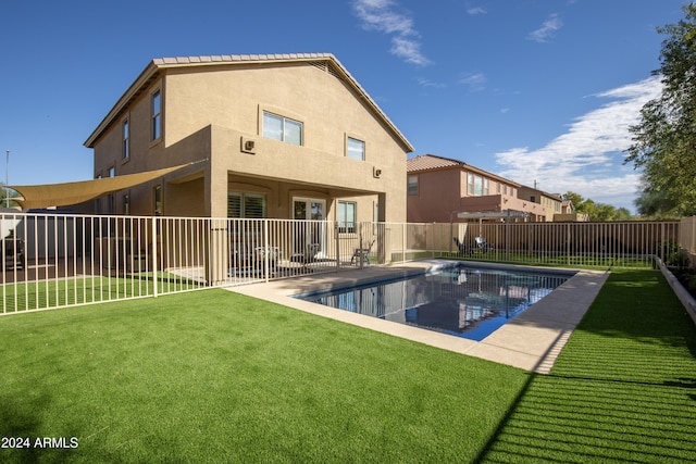 back of house featuring a yard, a fenced in pool, and a patio