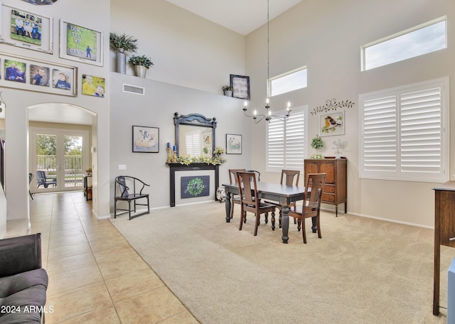 carpeted dining space featuring a high ceiling and a notable chandelier