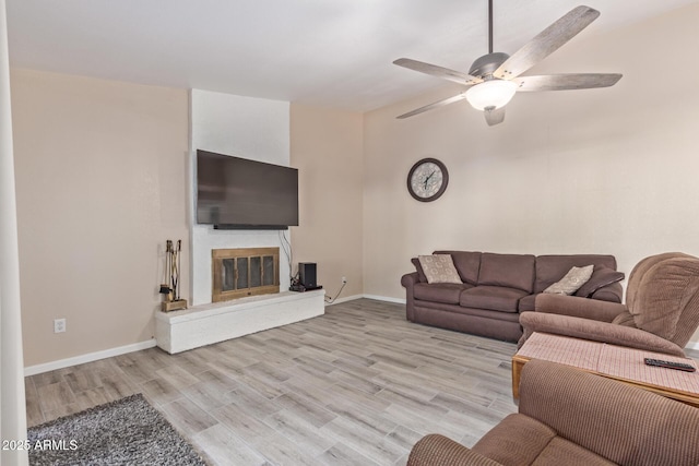 15849 N 46th Pl, Phoenix, AZ 85032 - living room featuring ceiling fan, light wood finished floors, baseboards, and a glass covered fireplace