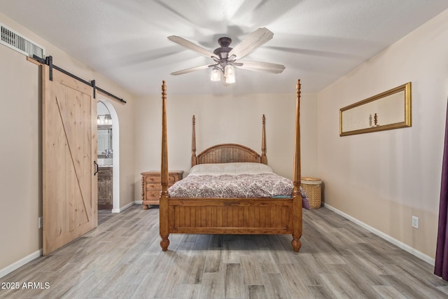 15849 N 46th Pl, Phoenix, AZ 85032 - bedroom with a barn door, wood finished floors, and baseboards