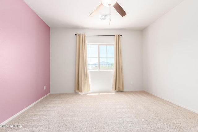 empty room featuring ceiling fan and light colored carpet