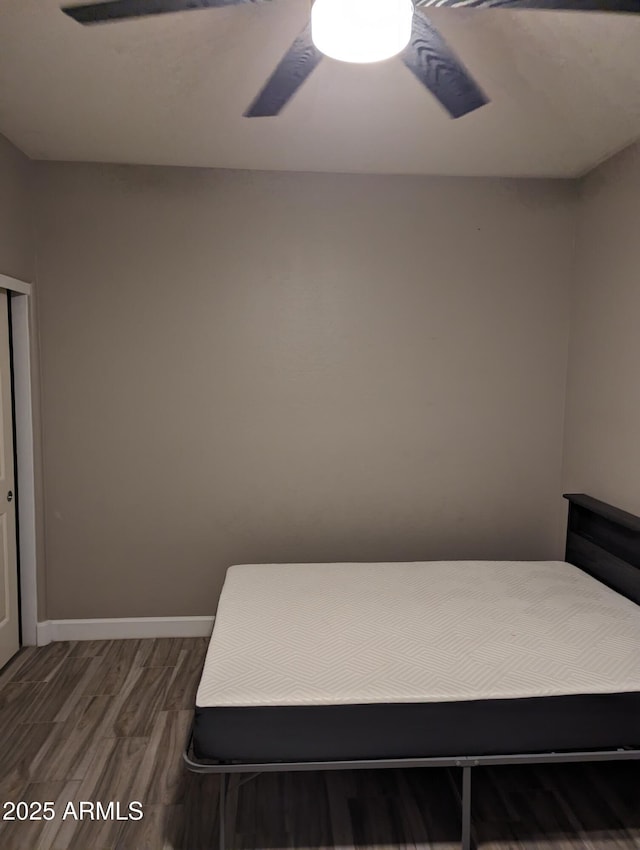 bedroom featuring a ceiling fan, baseboards, and wood finished floors