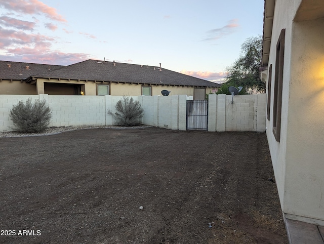 exterior space featuring a gate, fence, and stucco siding