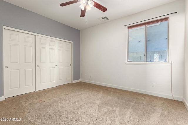 unfurnished bedroom with carpet floors, a closet, visible vents, a ceiling fan, and baseboards