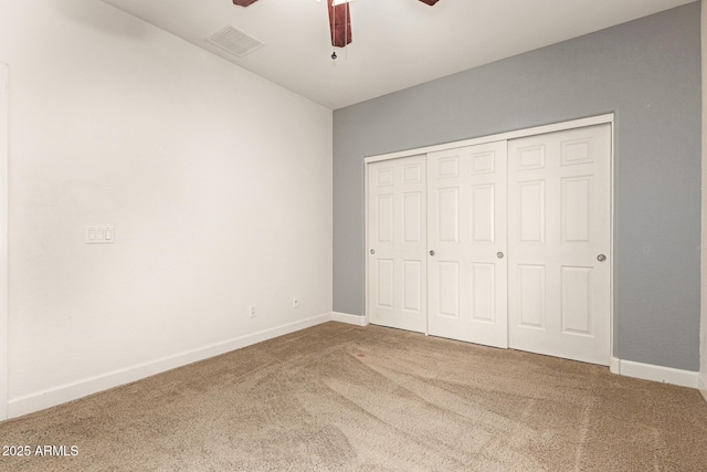 unfurnished bedroom with carpet floors, a closet, visible vents, ceiling fan, and baseboards