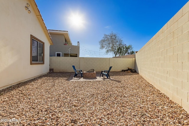 view of yard with a fenced backyard, a patio, and a fire pit