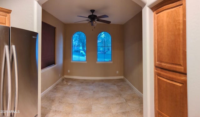 empty room featuring ceiling fan and baseboards