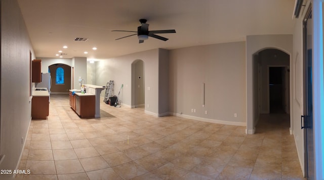 kitchen featuring visible vents, arched walkways, ceiling fan, light countertops, and recessed lighting