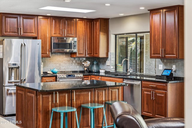 kitchen featuring stainless steel appliances, a center island, dark stone countertops, and decorative backsplash