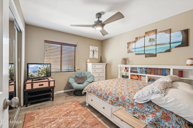 bedroom with light hardwood / wood-style flooring, a closet, and ceiling fan