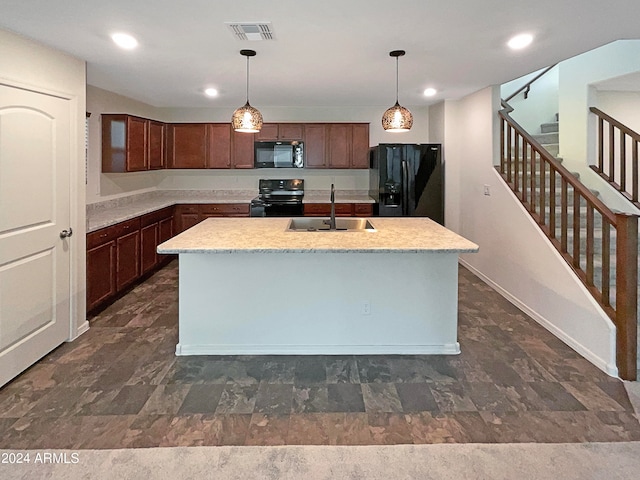 kitchen featuring black appliances, sink, dark brown cabinetry, pendant lighting, and a kitchen island with sink