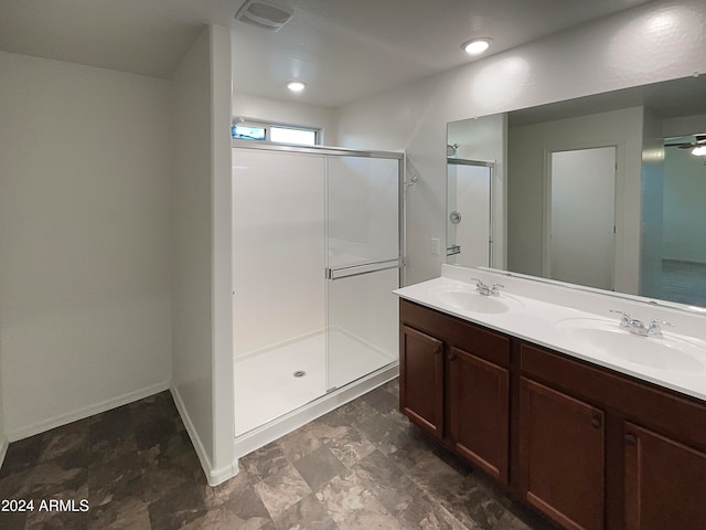 bathroom featuring vanity, ceiling fan, and a shower with door