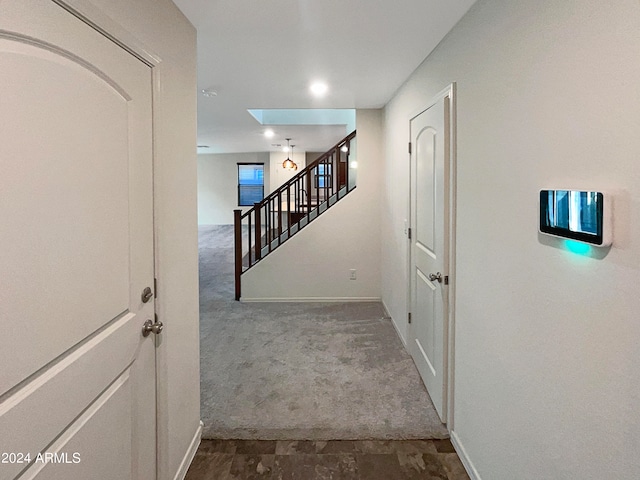 corridor featuring a skylight and carpet