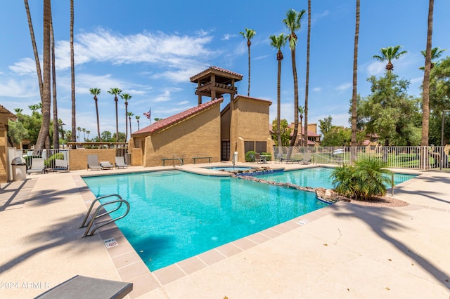 view of swimming pool featuring a hot tub and a patio