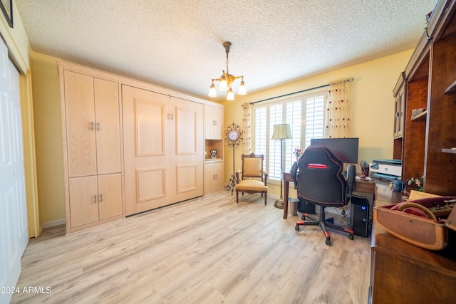 office area with a textured ceiling, light hardwood / wood-style floors, and an inviting chandelier