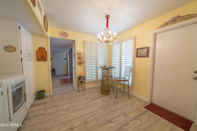 dining area featuring washer and dryer, light hardwood / wood-style floors, and a chandelier