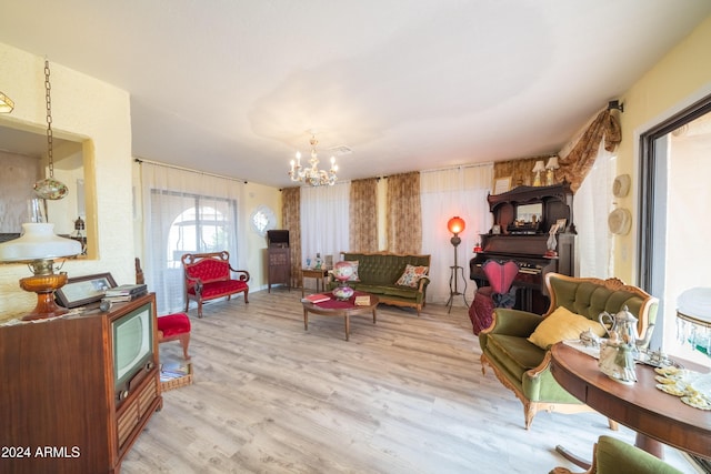 living room featuring a notable chandelier and light hardwood / wood-style flooring