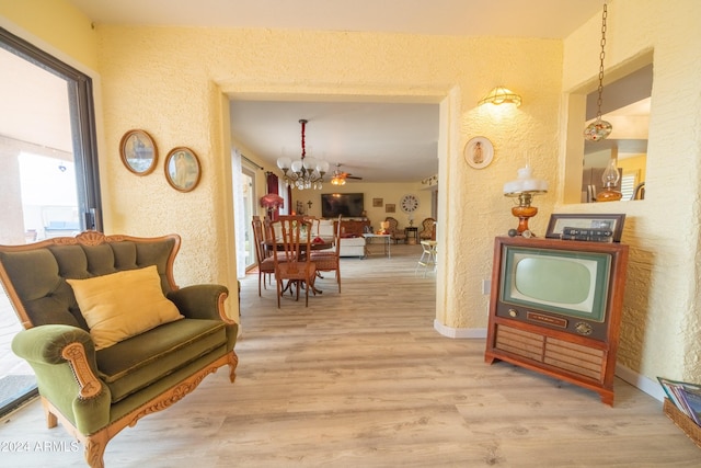 hallway featuring light hardwood / wood-style floors and an inviting chandelier