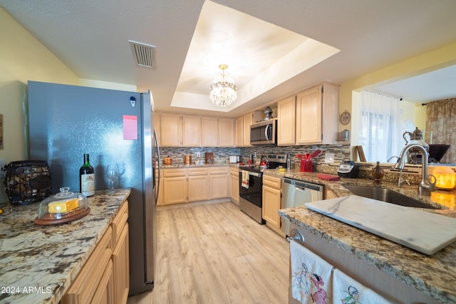 kitchen with sink, stainless steel appliances, a raised ceiling, light hardwood / wood-style floors, and light brown cabinetry