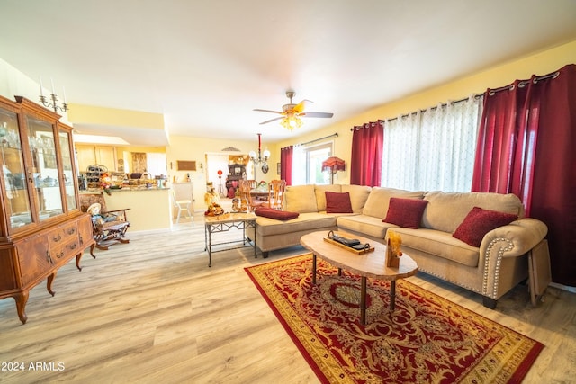 living room featuring light hardwood / wood-style flooring and ceiling fan with notable chandelier