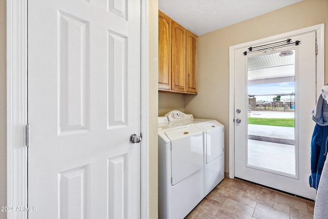 laundry area with washing machine and clothes dryer and cabinets