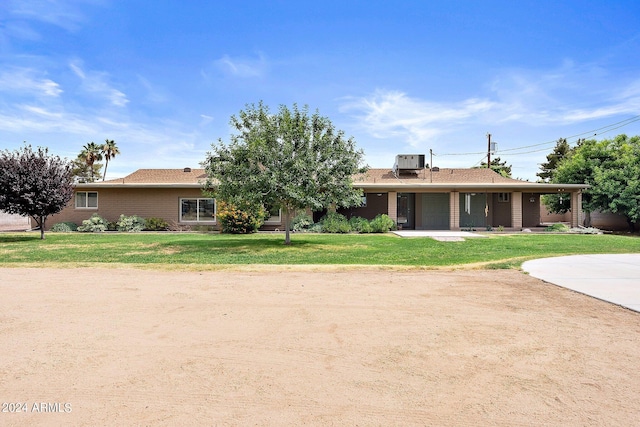 ranch-style home with a front yard and central air condition unit