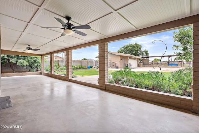 view of patio / terrace featuring a garage and ceiling fan