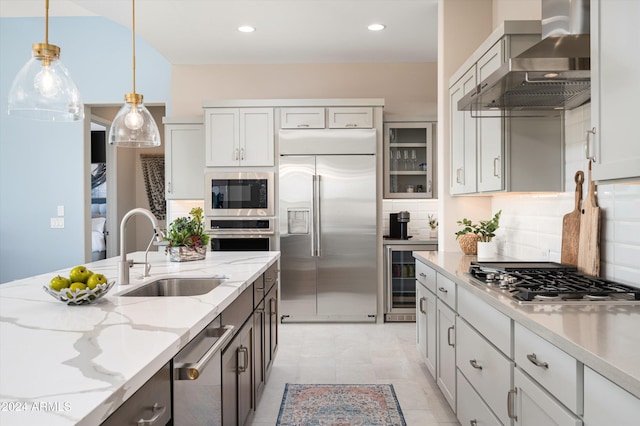 kitchen featuring sink, built in appliances, wall chimney exhaust hood, decorative backsplash, and wine cooler