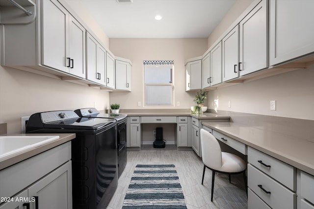 washroom featuring washer and dryer, cabinets, and light wood-type flooring