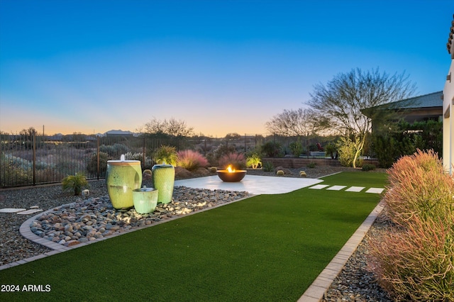 yard at dusk with a patio area