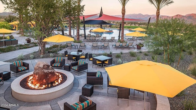 patio terrace at dusk with an outdoor living space with a fire pit and a mountain view