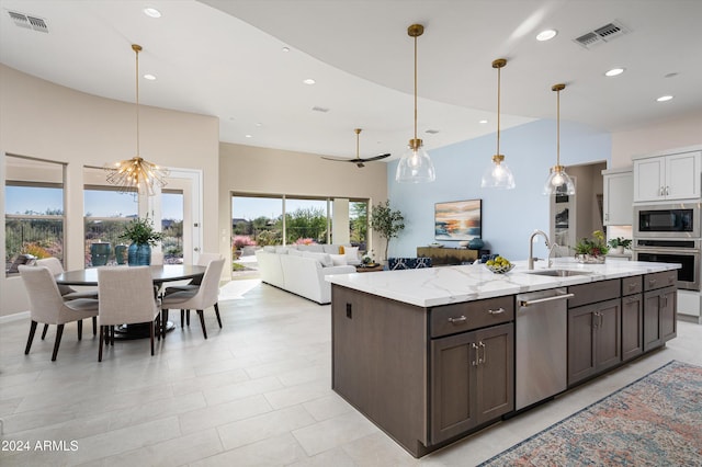 kitchen featuring stainless steel appliances, sink, dark brown cabinets, decorative light fixtures, and ceiling fan with notable chandelier