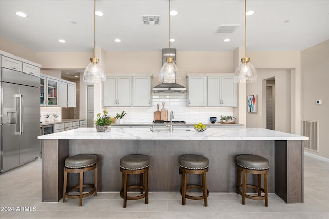 kitchen with decorative light fixtures, stainless steel built in refrigerator, and a spacious island