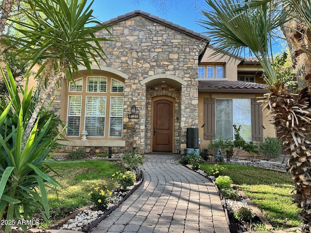 property entrance featuring a tile roof and stone siding