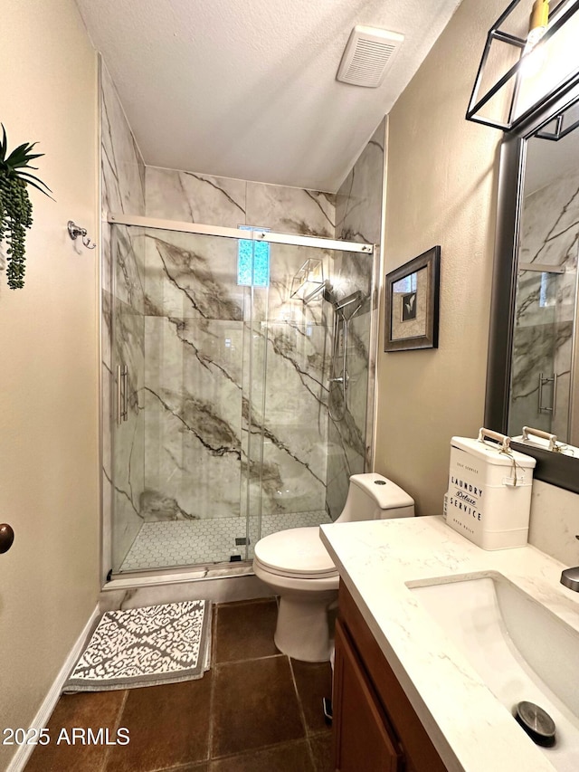 bathroom featuring vanity, visible vents, a marble finish shower, tile patterned flooring, and toilet