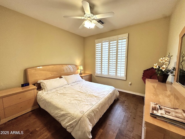 bedroom with ceiling fan, baseboards, and dark wood-style flooring