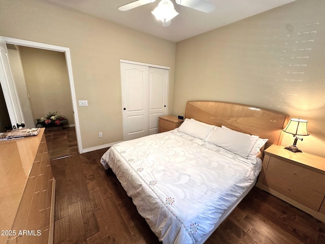 bedroom featuring a closet, baseboards, dark wood-type flooring, and a ceiling fan