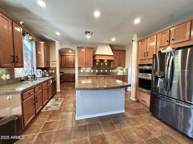 kitchen featuring tile countertops, stainless steel appliances, visible vents, and custom range hood