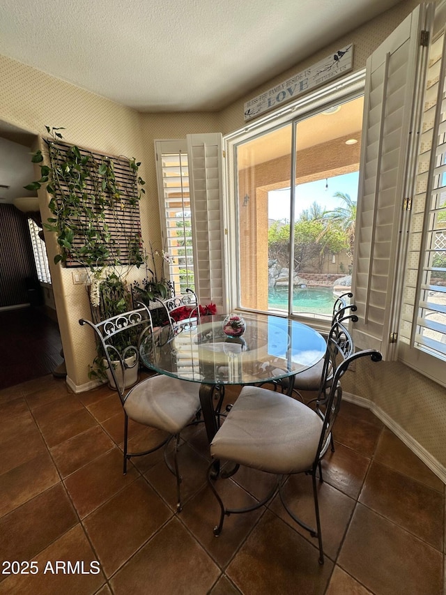 dining space with tile patterned flooring, baseboards, and a textured ceiling