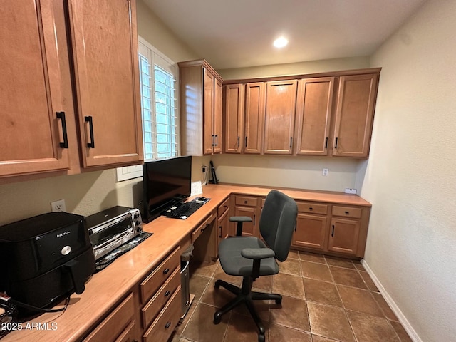 home office featuring built in study area and baseboards