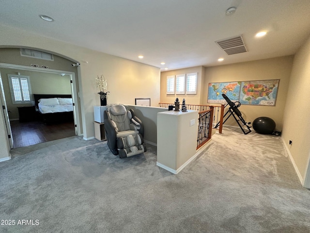 interior space featuring visible vents, baseboards, carpet, recessed lighting, and arched walkways