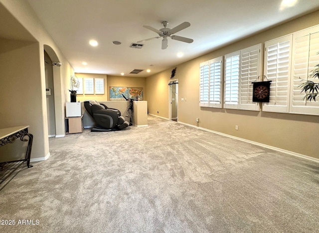 sitting room with visible vents, carpet floors, baseboards, and ceiling fan