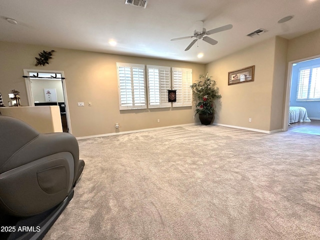 living area featuring visible vents, a ceiling fan, baseboards, and carpet floors