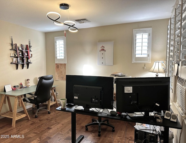 office space featuring visible vents, baseboards, and wood finished floors