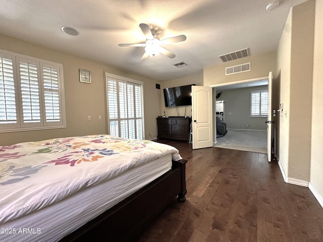 bedroom featuring visible vents, multiple windows, and dark wood-type flooring