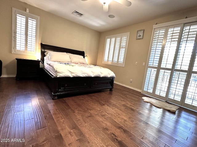 bedroom with visible vents, baseboards, dark wood-type flooring, and a ceiling fan